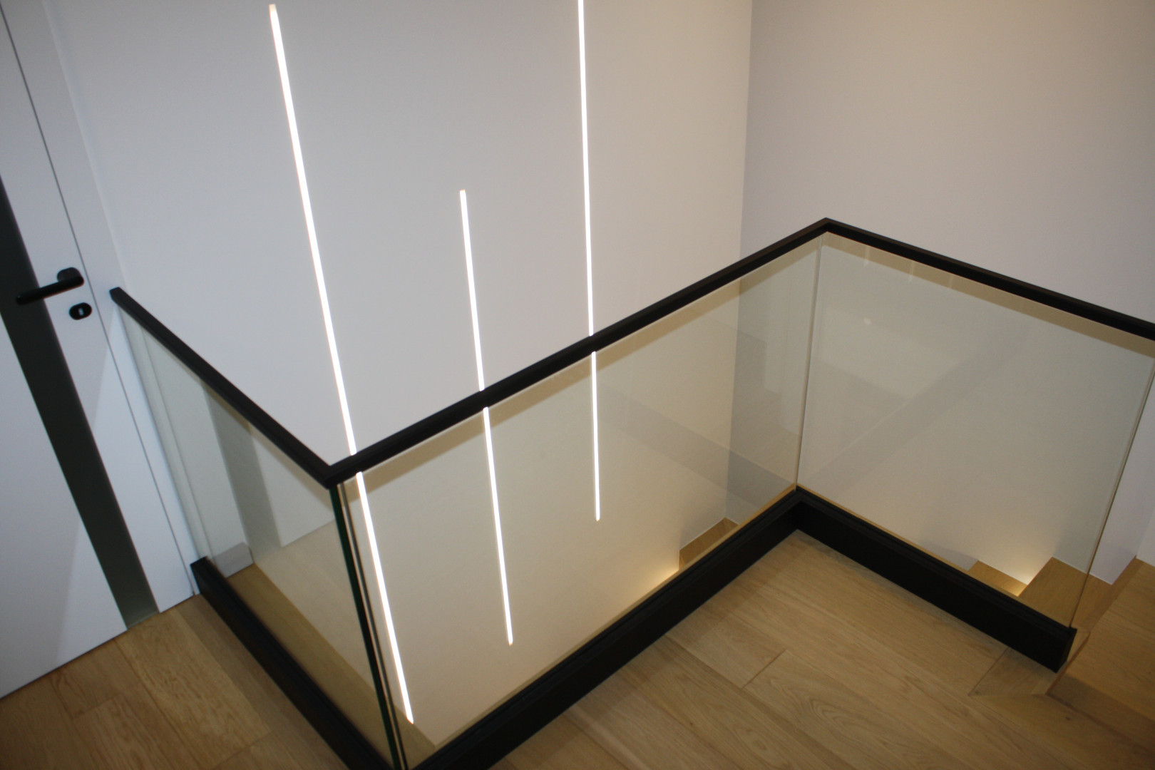 balustrada całoszklana na listwie aluminiowej w kolorze czarnym z poręczą nakładaną na szkło